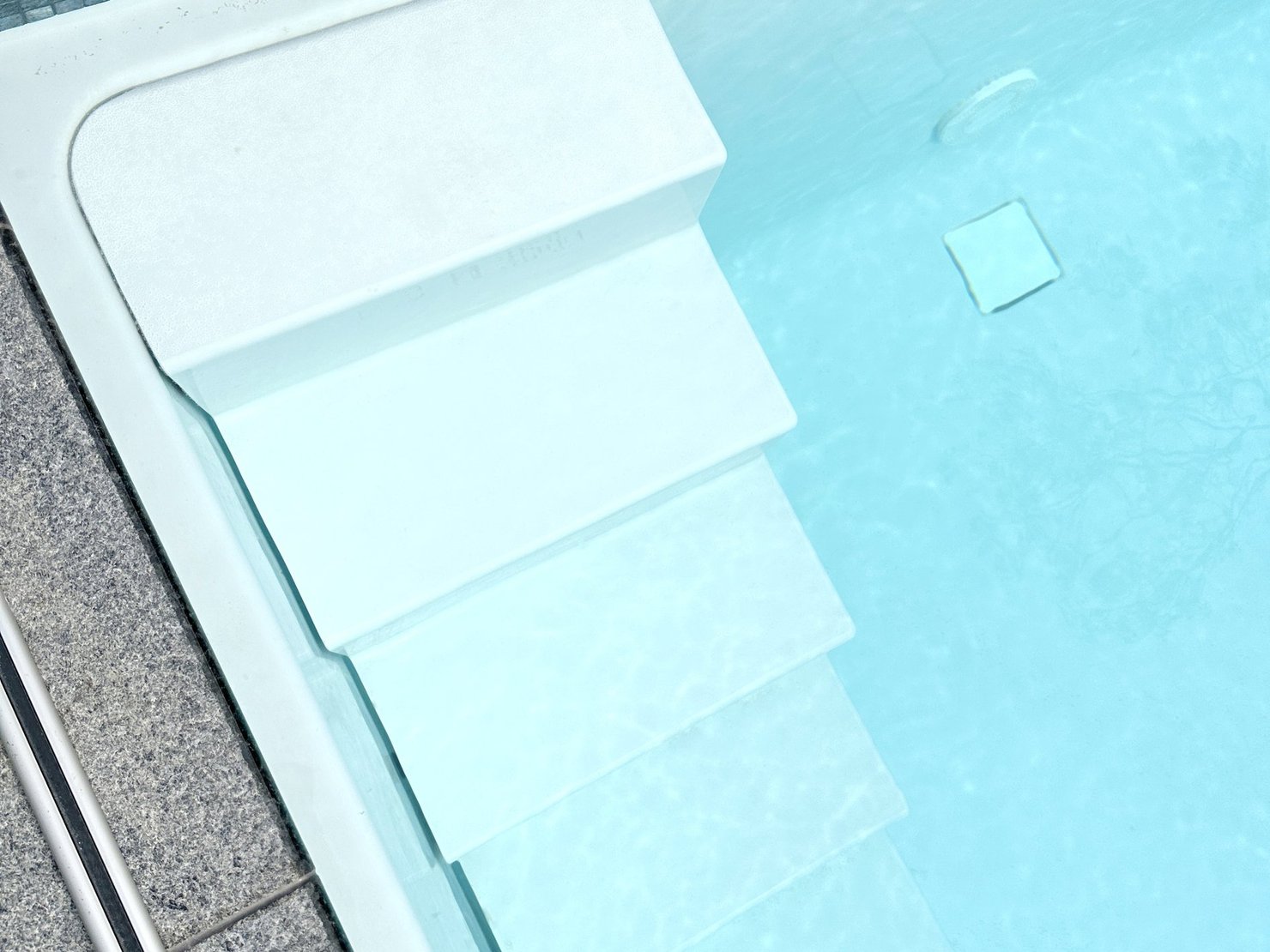 Detailaufnahme RivieraPool D·Line Classic „Bari“ mit seitlicher Bari-Treppe, 5-stufigem Einstieg und Farbe Papyrus – Ausstellung Hannover
