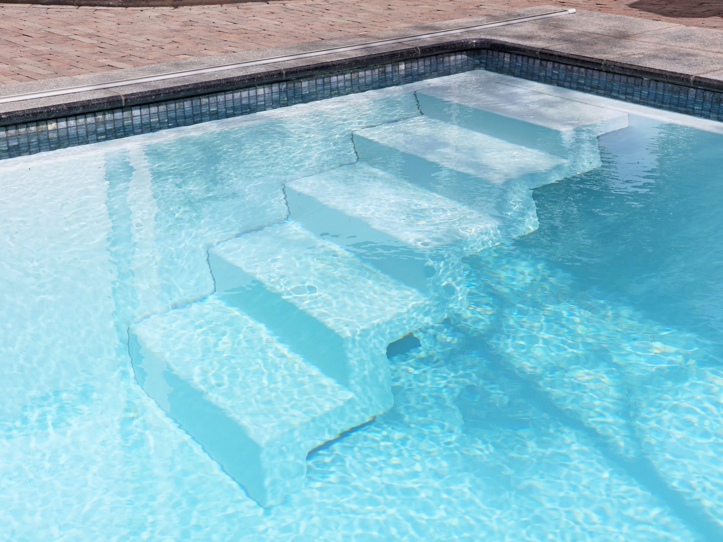 RivieraPool D·Line Classic „Bari“, Fertigschwimmbecken in Papyrus mit Mosaikdekor Ezarri Hematite und Polar White Einbauteilen – Detailansicht in Hannover
